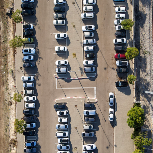 Top-down view of a full parking lot in Petah Tikva, showcasing arranged cars.